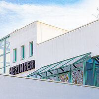 Firmenschild der Hezinger Maschinen GmbH am Unternehmensgebäude in Kornwestheim, Symbol für über 40 Jahre Erfahrung im Maschinenbau