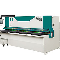 Moderne Tafelschere von Hezinger beim präzisen Schneiden von Blech in einer Werkstatt, hydraulisch betrieben, mit Digitalanzeige und Sicherheitsvorrichtungen.
